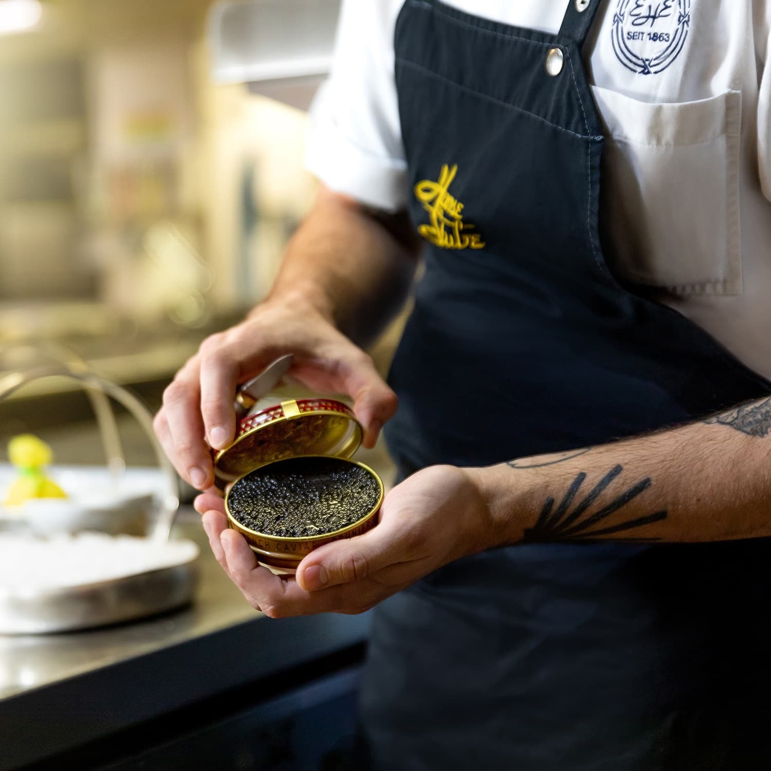 Chef with open can of caviar in gourmet restaurant Cologne