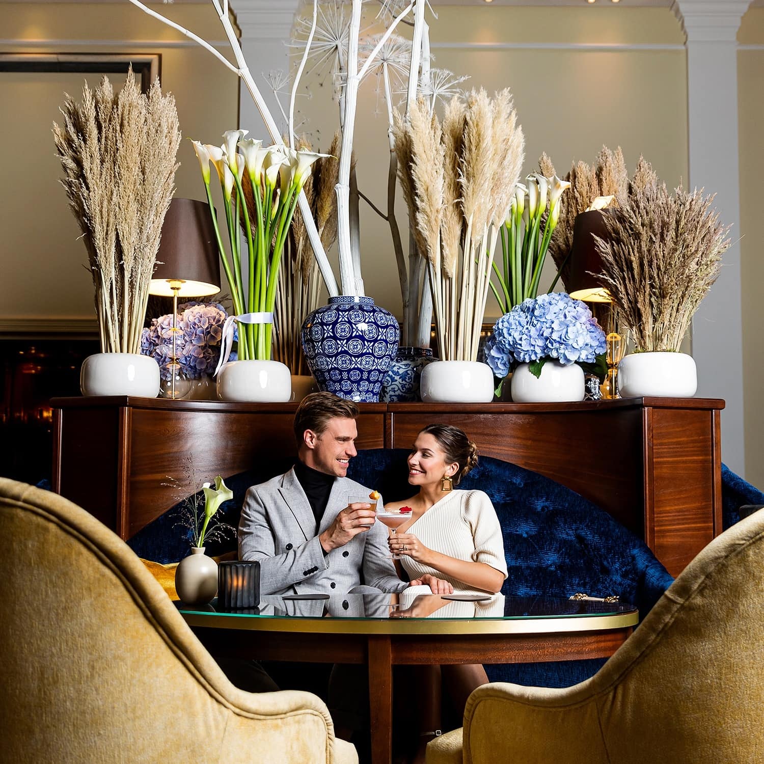 Couple sitting on a couch drinking cocktails at 5 star hotel Cologne 