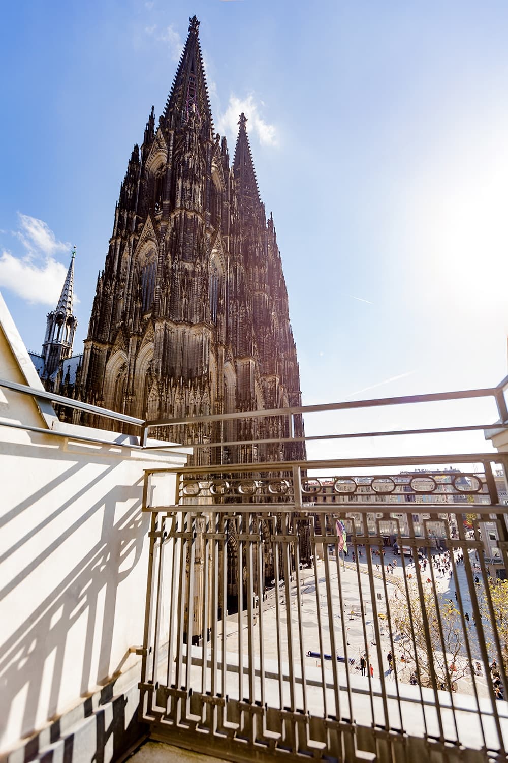 Blick von einem Balkon auf den Kölner Dom bei Sonnenschein